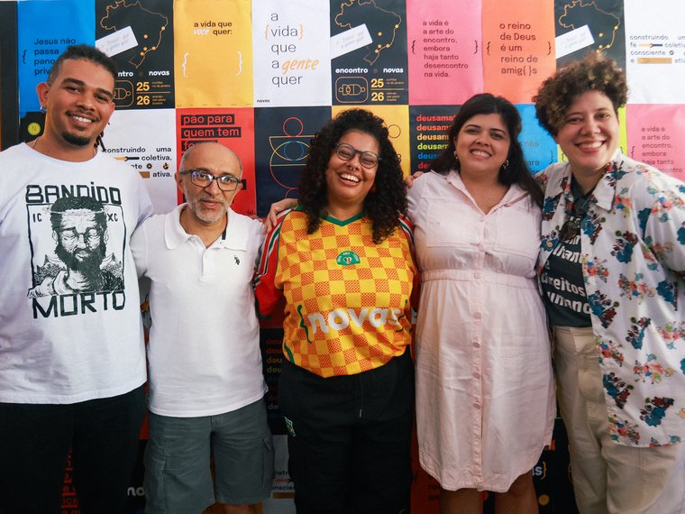 Grupo posando junto na parede de zines